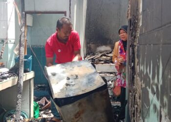 HASNAH  Mohamed melihat sebahagian daripada perkakas yang rosak selepas rumahnya terbakar di Kampung Gong Tok Nasek, Kuala Terengganu, hari ini. - UTUSAN/TENGKU DANISH TENGKU YUSOF