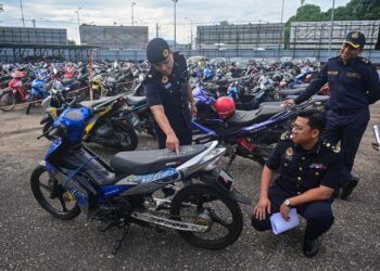 MOHD. Zamri Samion (kiri) menunjukkan motosikal yang disita dalam Operasi Khas Hari Raya Aidiladha (HRAA), Kuala Terengganu, semalam. - UTUSAN/PUQTRA HAIRRY ROSLI