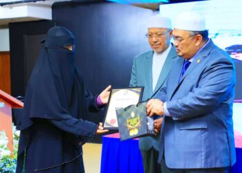 MOHAMED Fadzli Hassan (kanan) menyampaikan hadiah kepada salah seorang penerima Anugerah Saudagar Terbaik KGT  2023 sempena Majlis Pelancaran Cawangan Operasi Dinar Dirham Kelantan di Dewan Bunga Teratai, Kompleks Kota Darulnaim di Kota Bharu, Kelantan hari ini-UTUSAN/KAMARUL BISMI KAMARUZAMAN.