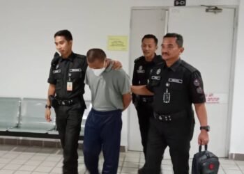 MOHD. Firdaus Mohd. Zahid (tengah) yang didapati bersalah mengedar dadah dibawa keluar dari Mahkamah Tinggi Kuala Terengganu, hari ini. - UTUSAN/TENGKU DANISH BAHRI TENGKU YUSOFF