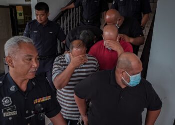 KESEMUA tertuduh diiring anggota polis selepas didakwa di Mahkamah Majistret, Ayer Keroh, Melaka atas pertuduhan memukul seorang lelaki sehingga parah. - UTUSAN/SYAFEEQ AHMAD