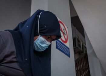 TERTUDUH dihadapkan ke Mahkamah Majistret, Ayer Keroh, Melaka atas pertuduhan menyamar sebagai staf BNM dan menipu ibu angkatnya. - UTUSAN/SYAFEEQ AHMAD