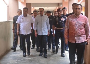 ANWAR Ibrahim (dua, kiri) ditemani Saifuddin Nasution Ismail (kiri) meninjau kuarters pegawai dan anggota polis yang mengalami kerosakan ketika hadir pada 
Majlis Ramah Mesra Perdana Menteri Bersama Warga KDN Negeri Terengganu di  IPD Marang, Marang, hari ini. - UTUSAN/PUQTRA HAIRRY ROSLI