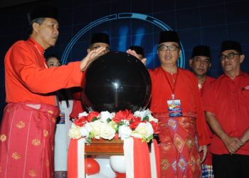 MOHAMAD Hassan (kiri) dan Yahya Jaafar menekap bebola kaca sebagai simbolik perasmian Mesyuarat UMNO Bahagian Johor Bahru di Hotel Opero, Johor Bahru.