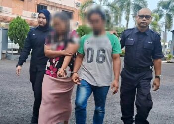 ANGGOTA polis mengiringi pasangan suami isteri yang disyaki mendera anak di Jalan Jabur Kubur, keluar selepas keluar dari Mahkamah Majistret Kemaman, hari ini. - UTUSAN/NIK NUR IZZATUL HAZWANI NIK ADNAN