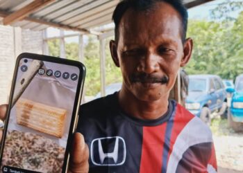 ALIAS Saras menunjukkan biskut yang dipercayai mengandungi racun yang dimakan anaknya di sebuah kebun, di  Kampung Dadong, Kemaman, semalam. - UTUSAN/NIK NUR IZZATUL HAZWANI NIK ADNAN