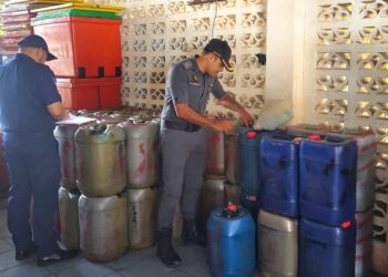 ANGGOTA Penguat Kuasa KPDN memeriksa tong berisi petrol yang disimpan tanpa kebenaran di sebuah premis di Kuala Kemaman, semalam.