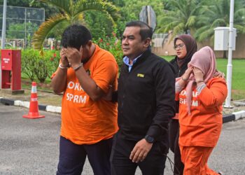 PASANGAN suami isteri yang ditahan bagi membantu siasatan kes salah guna kuasa dibawa di Mahkamah Majistret Kuala Terengganu, hari ini. - UTUSAN/PUQTRA HAIRRY ROSLI