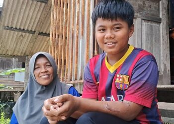 MOHD. Daynail Haikal Alias bersama ibunya, Roslina Ahmad ketika ditemui di rumah mereka di Kampung Air Putih, Kemaman, hari ini. - UTUSAN/NIK NUR IZZATUL HAZWANI NIK ADNAN