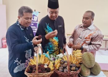 MOHD. Fadlee Hassan (kanan) menunjukkan antara buah-buahan tempatan pada Kempen Lebihkan Makan Buah-buahan dan Sayur-sayuran Tempatan di SK Bukit Kuang, hari ini. - UTUSAN/
NIK NUR IZZATUL HAZWANI NIK ADNAN