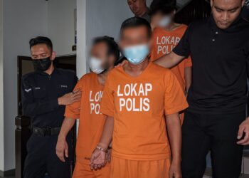 SUSPEK (kanan) diiring anggota polis selepas dibawa ke Mahkamah Majistret, Ayer Keroh, Melaka bagi permohonan reman di hadapan Majistret Mazana Sinin. - UTUSAN/SYAFEEQ AHMAD