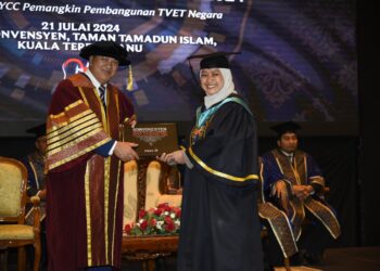 MOHD. Zahari Ismail (kiri) menyampaikan Anugerah Graduan Terbaik Diploma kepada seorang graduan pada Majlis Konvokesyen Politeknik dan Kolej Komuniti Negeri Terengganu di Kuala Terengganu, hari ini. - UTUSAN/KAMALIZA KAMARUDDIN