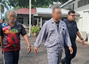 SEORANG warga emas (kiri) yang dipercayai merogol seorang murid perempuan dibawa keluar di Mahkamah Majistret Kemaman, hari ini. - UTUSAN/NIK NUR IZZATUL HAZWANI NIK ADNAN