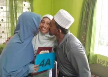SITI SAFFANATUN NAFISAH  menerima ciuman tahniah daripada bapanya, Abd. Mungin@Abd.Munir Jamadi dan ibunya, Siti Sharifah Mohd. Subohi di Kampung Parit Dahlan, Benut, Pontian.