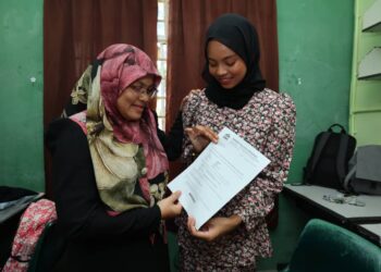 NUR Azra Azmi  (kanan) ditemani ibunya, Rohani Ismail teruja dapat mendaftar masuk ke pengajian Asasi STEM di UMT, Kuala Nerus, hari ini.