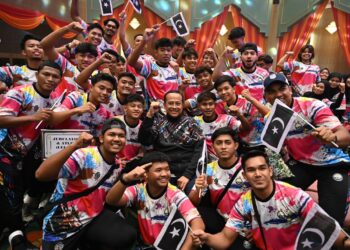 AHMAD Samsuri Mokhtar (tengah) bergambar bersama sebahagian daripada atlet Terengganu selepas Majlis Penyerahan Bendera Kontinjen Sukma Negeri Terengganu  di Kuala Terengganu, hari ini. - UTUSAN/TENGKU DANISH BAHRI TENGKU YUSOFF