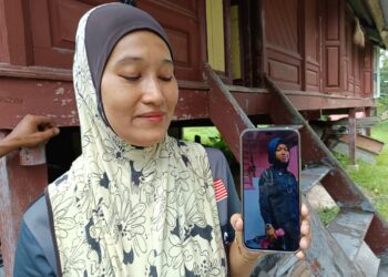 SITI Fatimah Mat Lazim menunjukkan gambar anaknya, Fiffy Arnatasya Abdullah yang dilaporkan hilang sebelum ini ketika ditemui pemberita di Kampung Terusan Juasseh, Kuala Pilah baru-baru ini.-UTUSAN/NOR AINNA HAMZAH.