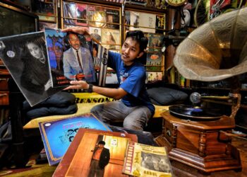 MUHAMAD Aidil Fakhri Ridzwan menunjukkan koleksi piring hitam artis-artis lama yang dimilikinya di Taman Panchor Jaya, Seremban, Negeri Sembilan. – UTUSAN/MOHD. SHAHJEHAN MAAMIN