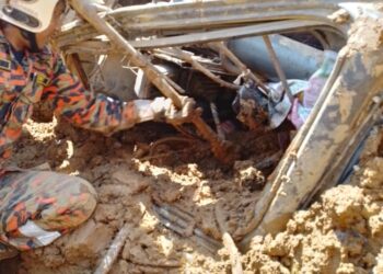 ANGGOTA bomba mengeluarkan mangsa tersepit dalam jengkaut yang terbalik dekat lereng bukit di Pengkalan Hulu, Gerik hari ini. - UTUSAN/IHSAN JBPM