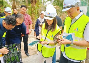 Nie Ching dan Pengerusi Jawatankuasa Perumahan dan Kerajaan Tempatan negeri, Datuk Mohd. Jafni Md. Shukor (kanan) menunjukkan kawasan liputan internet sebelum dan selepas menara beroperasi selepas melawat Tapak Menara Komunikasi Kampung Murni Jaya 2, Kulai.