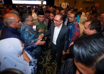 ANWAR Ibrahim bersalaman dengan orang ramai ketika menghadiri majlis perasmian Forum Global Madani di Kuala Lumpur, semalam. - UTUSAN/SADDAM YUSOFF