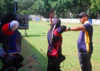 ZAINUDDIN Talib (kanan) sedang melatih dua atlet perempuan dalam keadaan papan sasar yang berlubang ketika menjalani latihan di Lapang Sasar MSN, Ayer Keroh, Melaka. - UTUSAN/AMRAN MULUP