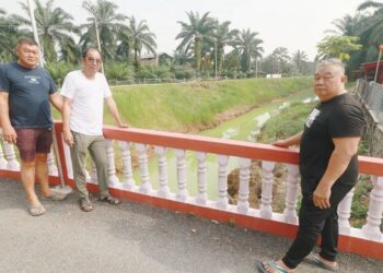 LO Chai Ann (kanan) bersama penduduk menunjukkan air sungai yang tercemar dan bertukar warna kepada hijau di Kampung Chuah, Port Dickson sejak lima hari lalu.