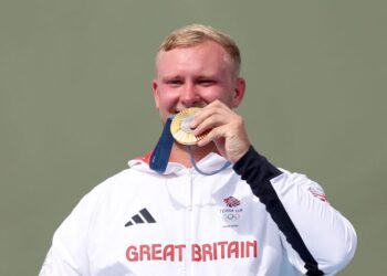 Pemenang pingat emas, Nathan Hales dari Britain meraikan kejayaan di atas podium pada penghujung perlawanan akhir acara trap menembak lelaki di Sukan Olimpik Paris 2024 di Pusat Menembak Chateauroux pada 30 Julai 2024.