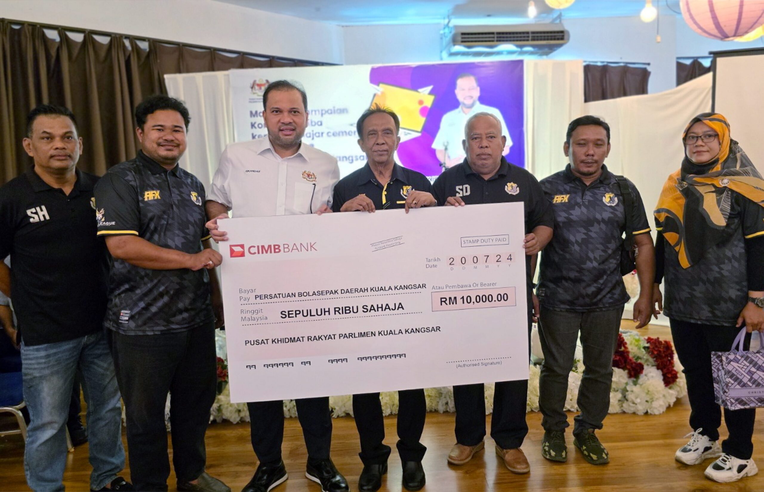 ISKANDAR Dzulkarnain Abdul Khalid (tiga dari kini) bersama wakil Persatuan Bola Sepak Daerah Kuala Kangsar menyampaikan cek kepada persatuan itu di Kuala Kangsar semalam. - UTUSAN/FADZIL ZAINOL