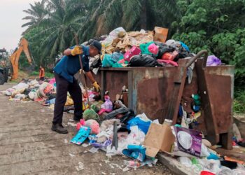 PEKERJA pembersihan MPTI mengutip sampah di Kampung Bahagia, Teluk Intan ketika tinjauan kelmarin. – UTUSAN/AIN SAFRE BIDIN