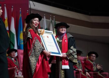 SALAH seorang graduan yang berjaya menamatkan pengajian PhD menerima cenderahati dalam majlis konvokesyen CityU, baru-baru ini.