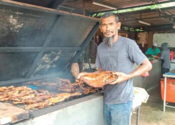 AZMAN Zainuddin menunjukkan ikan tilapia dan patin salai yang kurang dibeli oleh  pelanggan di Kampung Jerantut Feri di Jerantut, Pahang. – UTUSAN/HARIS FADILAH AHMAD