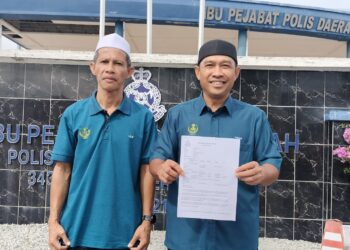 ABDUL Yunus Jamahri (kanan) menunjukkan laporan polis yang dibuat di IPD Kerian berhubung 10 premis menjalankan aktiviti judi dalam talian di Kerian. – UTUSAN/WAT KAMAL ABAS