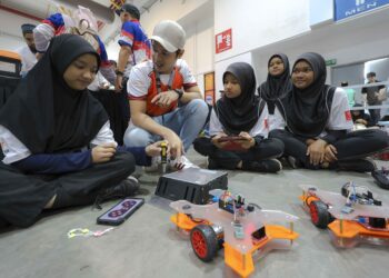 Muhammad Asif Zulkifli menerangkan kepada peserta mengenai teknologi robot kepada  pelajar yang menyertai pertandingan Felda Robotic Challenge 2024 sempena Sambutan Hari Peneroka Felda di Serdang  baru-baru ini. – UTUSAN/FARIZ RUSADIO