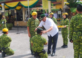 SHAMSUL ANUAR Nasarah memakaikan beret kepada seorang anggota sempena Hari Ulang Tahun Rela Ke-52 di ALARM, Sungai Udang, Melaka. - UTUSAN/AMRAN MULUP