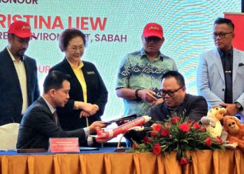 KETUA Pegawai Eksekutif STB, Julinus Jeffrey Jimit dan Chester Voo bertukar dokumen memorandum persefahaman kerjasama strategik STB dan AirAsia, sambil disaksikan oleh Christina Liew di Kota Kinabalu semalam.