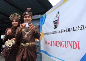 MUHAMMAD Syafiq Mohd. Rozei (kanan) bersama isterinya, Munirah Yahya selepas membuang undi di Pusat Mengundi Sk Jawi, Nibong Tebal, Pulau Pinang.-UTUSAN/IQBAL HAMDAN