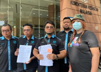 HISHAMUDDIN Hashim bersama mangsa dikenali Alice tampil menyerahkan surat aduan kepada KKM di Putrajaya. - UTUSAN/KAMARIAH KHALIDI