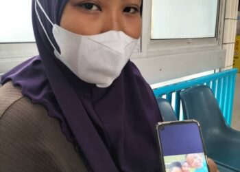 NURAIN Hasnorizal menunjukkan gambar dia dan dua anaknya iaitu Muhammad Akil Syauqi Nur Sufyan dan Muhammad Luth Syauqi yang masih kritikal dan kini dirawat di Hospital Pulau Pinang (HPP) selepas termakan keropok mengandungi racun tikus di Kulim, Kedah, kelmarin.