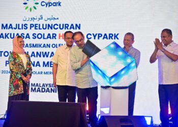 ANWAR Ibrahim (tengah) melakukan gimik pada Majlis Peluncuran Loji Janakuasa Solar Hibrid di Cypark Solar Merchang, Marang, hari ini. - UTUSAN/PUQTRA HAIRRY ROSLI