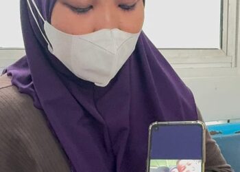 NURAIN HASNORIZAL menunjukkan gambar dia bersama dua anak lelakinya iaitu Muhammad Akil Syauqi dan Muhammad Luth Syauqi ketika ditemui di Hospital Pulau Pinang, kelmarin.