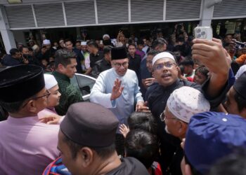 ANWAR Ibrahim beramah mesra dengan orang ramai selepas hadir menunaikan solat Jumaat di Surau An-Najah Presint 9, Putrajaya. - UTUSAN/FAISOL MUSTAFA