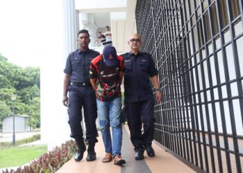 FIRDAUS Farok (tengah) didakwa di Mahkamah Majistret Balik Pulau atas tiga pertuduhan berasingan termasuk menghalang tugas polis serta memandu van secara melulu.-UTUSAN/IQBAL HAMDAN