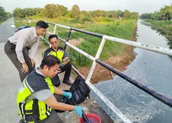 AHLI Dewan Undangan Negeri (ADUN) Chu­ah, Yew Boon Lye (kiri) turut melihat sampel air yang diambil pihak AS susulan aduan pencemaran air sungai oleh penduduk di Kampung Chuah, Port Dickson, semalam.