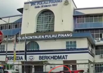 TANGKAP layar satu rakaman video menunjukkan seorang wanita (dalam bulatan merah) cuba mengganggu seorang pengguna jalan raya berhadapan ibu pejabat polis kontinjen (IPK) Pulau Pinang di Jalan Penang, baru-baru ini.