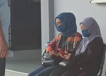 NUR Maizatul Khairiah Mohd. Nazri (kanan) hadir ke Mahkamah Majistret Kuala Pilah hari ini bagi didakwa atas kesalahan membuat laporan polis palsu diugut sehingga mengalami kecederaan, minggu lalu.-UTUSAN/NOR AINNA HAMZAH.