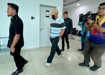 TERTUDUH (dua dari kiri) berjalan keluar dari mahkamah selepas berdepan pertuduhan menyalahgunakan harta kerajaan negeri melibatkan wang berjumlah RM81,585.04 di Mahkamah Sesyen Kangar, Perlis hari ini.-UTUSAN/ASYRAF MUHAMMAD
