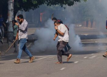 PENUNJUK perasaan menyelamatkan diri selepas polis melepaskan gas pemedih mata semasa demontrasi antikuota di Universiti Dhaka.- AGENSI