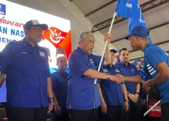 AHMAD Zahid Hamidi (dua dari kiri) menyerahkan Bendera Barisan Nasional kepada Ketua Pusat Daerah Mengundi (PDM) di Balai Rakyat Bukit Cekati, Gua Musang, Kelantan, hari ini.UTUSAN/AIMUNI TUAN LAH.