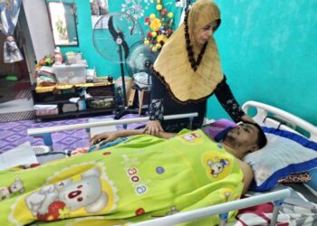 ZAITUN Hamzah bersama anaknya, Muhammad Azizul Shahrin Mohd. Amin yang terlantar akibat penyakit saraf di rumahnya di Rumah Sewa Sani, Jalan Parit Betak, Benut, Pontian, Johor. – UTUSAN/MUHAMMAD ZIKRI